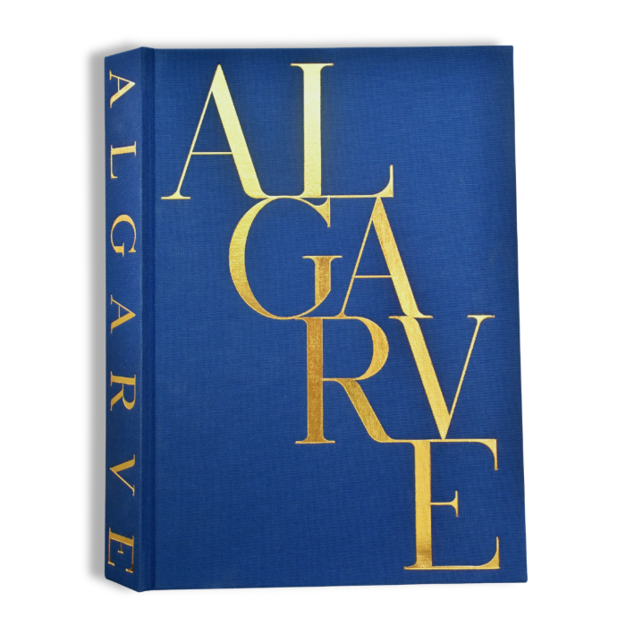A hardcover book with a textured royal blue cover and spine, featuring the title 'ALGARE' in large, elegant gold serif letters, shown on a clean white background.